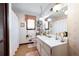Bathroom featuring double sinks, large mirror, and decorative wallpaper at 655 Stone Harbor Sw Pkwy, Marietta, GA 30060