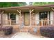 Inviting front porch with rocking chairs, brick accents, and manicured shrubs, offering a cozy outdoor space at 655 Stone Harbor Sw Pkwy, Marietta, GA 30060