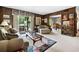 Comfortable living room features wood paneling, large windows, plush seating, and a view into the dining area at 655 Stone Harbor Sw Pkwy, Marietta, GA 30060