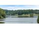 Picturesque lake view with tree-lined shores and a wooden bridge in the distance, showcasing the natural beauty at 116 Crooked Lake Park, Villa Rica, GA 30180