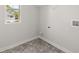 Functional laundry room with gray flooring, utility connections, and natural light at 116 Crooked Lake Park, Villa Rica, GA 30180