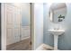 Charming powder room boasts pedestal sink, round mirror, and tasteful blue walls at 1232 Candler Ct, Morrow, GA 30260