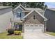 Charming two-story home featuring stone accents, a two-car garage, and well-maintained landscaping at 1232 Candler Ct, Morrow, GA 30260