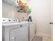 Functional laundry room with washer, dryer, and storage shelving for supplies at 1232 Candler Ct, Morrow, GA 30260