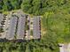 Aerial view of townhomes, surrounded by lush trees with ample parking and well-maintained landscaping at 4221 Rogers Creek Ct, Duluth, GA 30096
