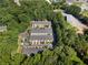 Aerial view of townhomes, surrounded by lush trees with ample parking and well-maintained landscaping at 4221 Rogers Creek Ct, Duluth, GA 30096