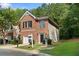 Well-maintained townhome exterior features a brick facade, attached garage, and lush green lawn at 4221 Rogers Creek Ct, Duluth, GA 30096