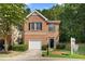 Beautiful townhome exterior with brick facade, garage, lush green lawn, and inviting curb appeal at 4221 Rogers Creek Ct, Duluth, GA 30096