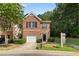 Charming brick two-story townhome with a single-car garage, manicured bushes, and a well-kept lawn at 4221 Rogers Creek Ct, Duluth, GA 30096