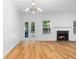 Bright living room featuring hardwood floors, a fireplace, and abundant natural light from the windows and french doors at 4221 Rogers Creek Ct, Duluth, GA 30096