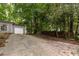 Spacious driveway with room for multiple cars leading to a home with an attached garage and lush landscaping at 4672 Satellite Blvd, Duluth, GA 30096