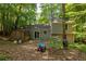 Backyard view of the home with a shed, mature trees, and a patio area, providing a natural setting at 4672 Satellite Blvd, Duluth, GA 30096