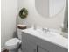 Stylish half-bathroom with a round mirror and gray vanity with modern fixtures at 916 Gambino Trce, Peachtree City, GA 30269
