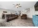 Cozy living room boasts plush leather seating, ceiling fan, and convenient access to kitchen and stairway at 916 Gambino Trce, Peachtree City, GA 30269