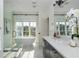 Bright bathroom with a freestanding tub, marble floors, and a double vanity with quartz countertop at 100 Villa Magnolia Ln, Alpharetta, GA 30009