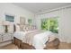 Comfortable bedroom with a large window, hardwood floors, and neutral decor at 100 Villa Magnolia Ln, Alpharetta, GA 30009