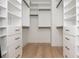 Walk-in closet features custom shelving, drawers, and wood floors for organized storage at 100 Villa Magnolia Ln, Alpharetta, GA 30009