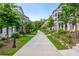 Landscaped walkway through a residential community with sidewalks, trees, and plants at 100 Villa Magnolia Ln, Alpharetta, GA 30009