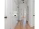 Hallway with light wood floors and white walls, closets and doors, leading to the other rooms at 100 Villa Magnolia Ln, Alpharetta, GA 30009