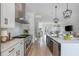 Bright, open kitchen with stainless steel appliances, island with seating, and modern pendant lighting at 100 Villa Magnolia Ln, Alpharetta, GA 30009