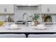 Detailed shot of kitchen island with stainless steel faucet, dinnerware, and center island seating at 100 Villa Magnolia Ln, Alpharetta, GA 30009