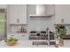 Close-up of a modern kitchen featuring stainless steel range, white subway tile, and quartz countertops at 100 Villa Magnolia Ln, Alpharetta, GA 30009