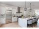 Contemporary kitchen featuring white cabinets, stainless steel refrigerator, and island with barstool seating at 100 Villa Magnolia Ln, Alpharetta, GA 30009