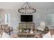 Cozy living room with a white brick accent wall, modern chandelier, and comfortable seating at 100 Villa Magnolia Ln, Alpharetta, GA 30009