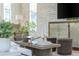 Close-up of living room decor with white brick wall, accent furniture, and hardwood floors at 100 Villa Magnolia Ln, Alpharetta, GA 30009
