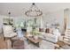 Airy living space with hardwood floors, a modern chandelier, and a view into the kitchen area at 100 Villa Magnolia Ln, Alpharetta, GA 30009