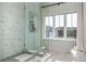 Contemporary main bathroom with a glass shower, soaking tub, marble tile, and a bright, airy ambiance at 100 Villa Magnolia Ln, Alpharetta, GA 30009