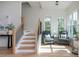 Bright foyer features a staircase with wood treads and railing, plus a sitting area near windows at 100 Villa Magnolia Ln, Alpharetta, GA 30009