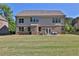 Expansive backyard showing the home's rear exterior, patio area with outdoor seating, and ample green space at 13015 Fox Rd, Alpharetta, GA 30005