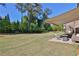 Spacious backyard with lush green grass, shade trees, and a patio with a seating area at 13015 Fox Rd, Alpharetta, GA 30005
