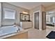 Bathroom with a large soaking tub, vanity with double sink, and tiled floors at 13015 Fox Rd, Alpharetta, GA 30005