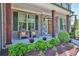 Inviting front porch with stone accents, wooden pillars, and a seating area at 13015 Fox Rd, Alpharetta, GA 30005