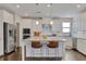 Modern kitchen features white cabinets, stainless steel appliances, a central island, and granite counters at 13015 Fox Rd, Alpharetta, GA 30005