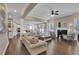 Open-concept living room with hardwood floors, fireplace, and views of the kitchen at 13015 Fox Rd, Alpharetta, GA 30005