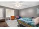 Cozy bedroom featuring gray walls, ceiling fan and hard wood floors, with a comfortable sitting area at 3514 Blackberry Se Ln, Conyers, GA 30094