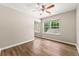 A bedroom with wood-look flooring, a ceiling fan, a window, and mirrored closet doors at 486 Windcroft Nw Cir, Acworth, GA 30101