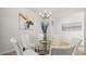 Dining room with glass table, white chairs, modern chandelier, and decorative wall art at 105 Crooked Lake Park, Villa Rica, GA 30180