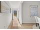 Hallway with decorative art and neutral colored walls leading to the entry door at 105 Crooked Lake Park, Villa Rica, GA 30180