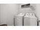 Clean laundry room with side-by-side washer and dryer, plus shelving for storage and organization at 105 Crooked Lake Park, Villa Rica, GA 30180