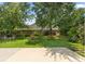 A well-maintained backyard with a green lawn, mature trees, a seating area and privacy fence at 110 Holly Mill Village Dr, Canton, GA 30114
