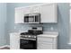 Modern kitchen features stainless steel appliances, white cabinets, and light countertops at 110 Holly Mill Village Dr, Canton, GA 30114