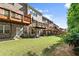 Exterior view of brick townhomes with wooden decks and a well-maintained grassy backyard at 2227 Foley Park St, Snellville, GA 30078