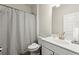 Bathroom with white vanity, toilet, and shower featuring a curtain and tiled surround at 2227 Foley Park St, Snellville, GA 30078