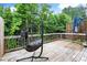 Deck with a swinging chair overlooking a lush green backyard and trees at 2227 Foley Park St, Snellville, GA 30078