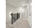 Upstairs hallway with neutral carpet and trim, featuring a dark wood railing and multiple doors at 2227 Foley Park St, Snellville, GA 30078