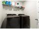 Laundry room equipped with black washer and dryer units and overhead shelving at 2227 Foley Park St, Snellville, GA 30078
